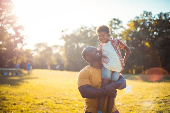 Father carrying his child outdoors